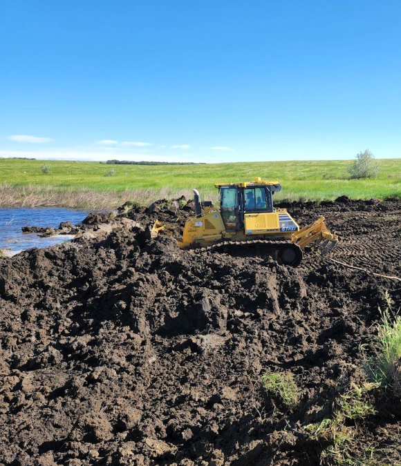 small yellow tractor moving dirt